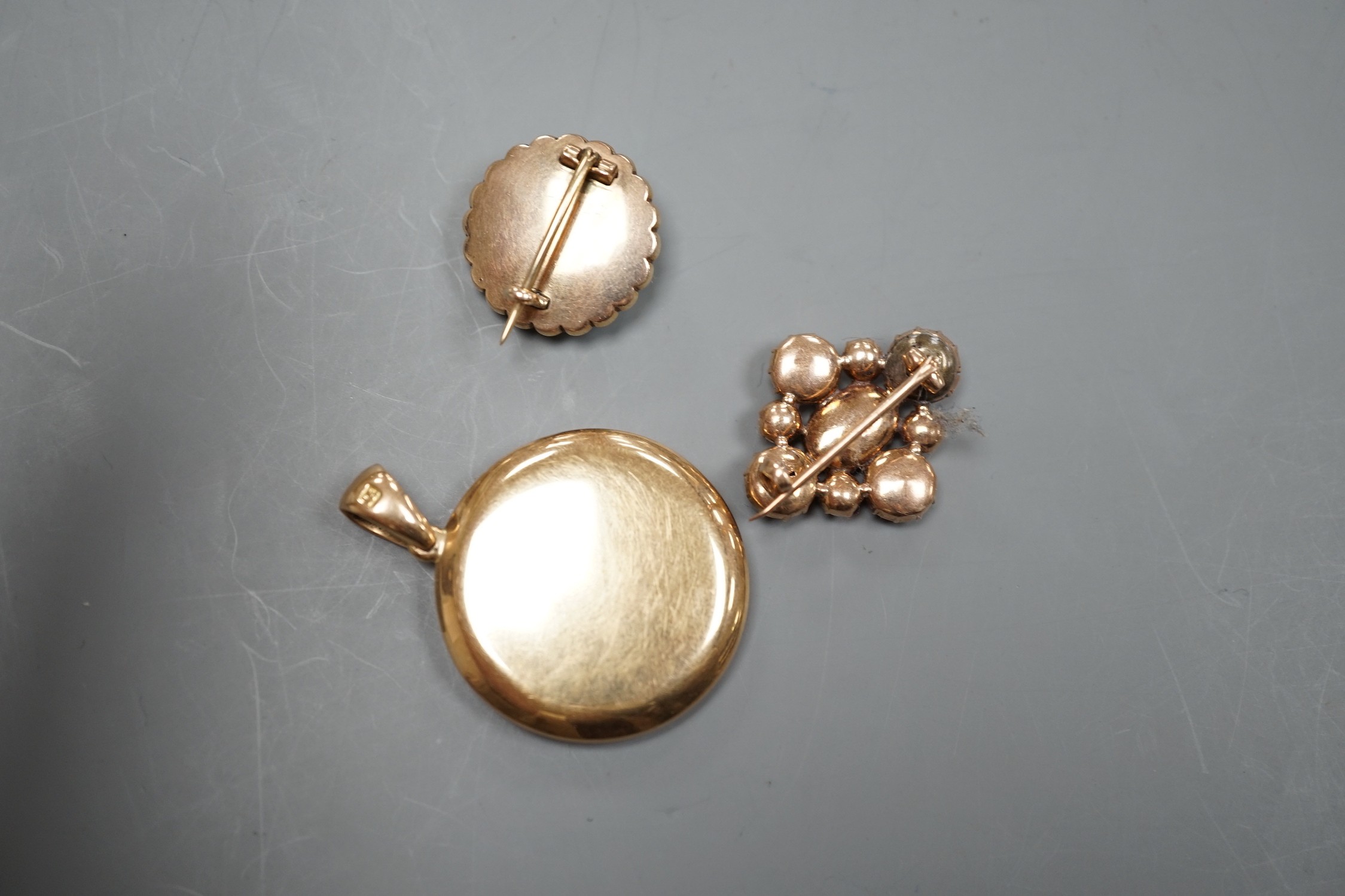 A Victorian yellow metal, turquoise and split pearl set circular brooch, 19mm, a similar garnet set brooch and a 15ct mounted miniature portrait pendant.